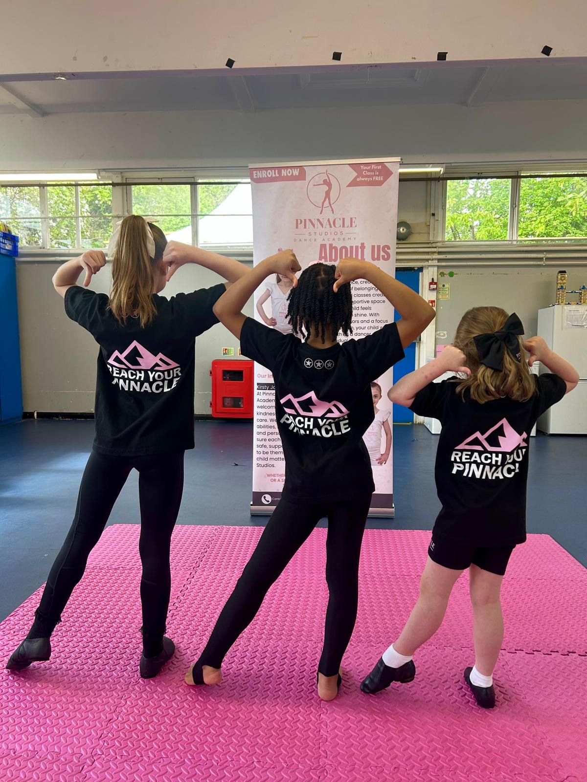 Pinnacle dancers proudly showing the Reach Your Pinnacle design on their academy kit