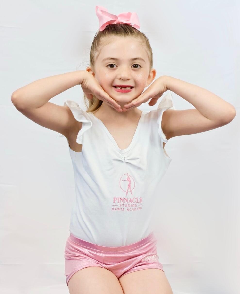 A young Pinnacle dancer in pink and white academy kit